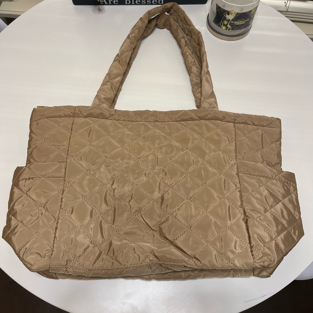 Thin quilted tote bag with side pockets.